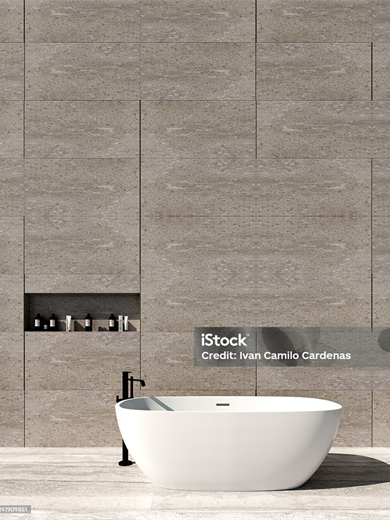 Freistehende Wanne vor einer Natursteinwand